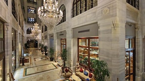 A grand lobby with marble floors, a large chandelier, and a bookstore. - Legacy Ottoman Hotel (Istanbul)