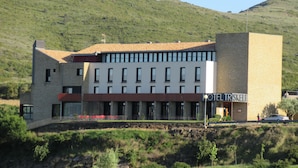 A hotel with a modern design, featuring a flat roof and a mix of stone and brick construction. - Triskel (Sos del Rey Catolico)
