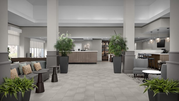 A modern lobby with a reception desk, seating area, and potted plants. - Hilton Garden Inn Annapolis (Annapolis)