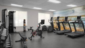 A gym with exercise equipment, including a treadmill, stationary bike, and weights.