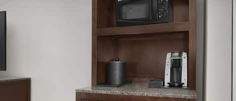 A kitchen with a microwave, coffee maker, and a dishwasher.