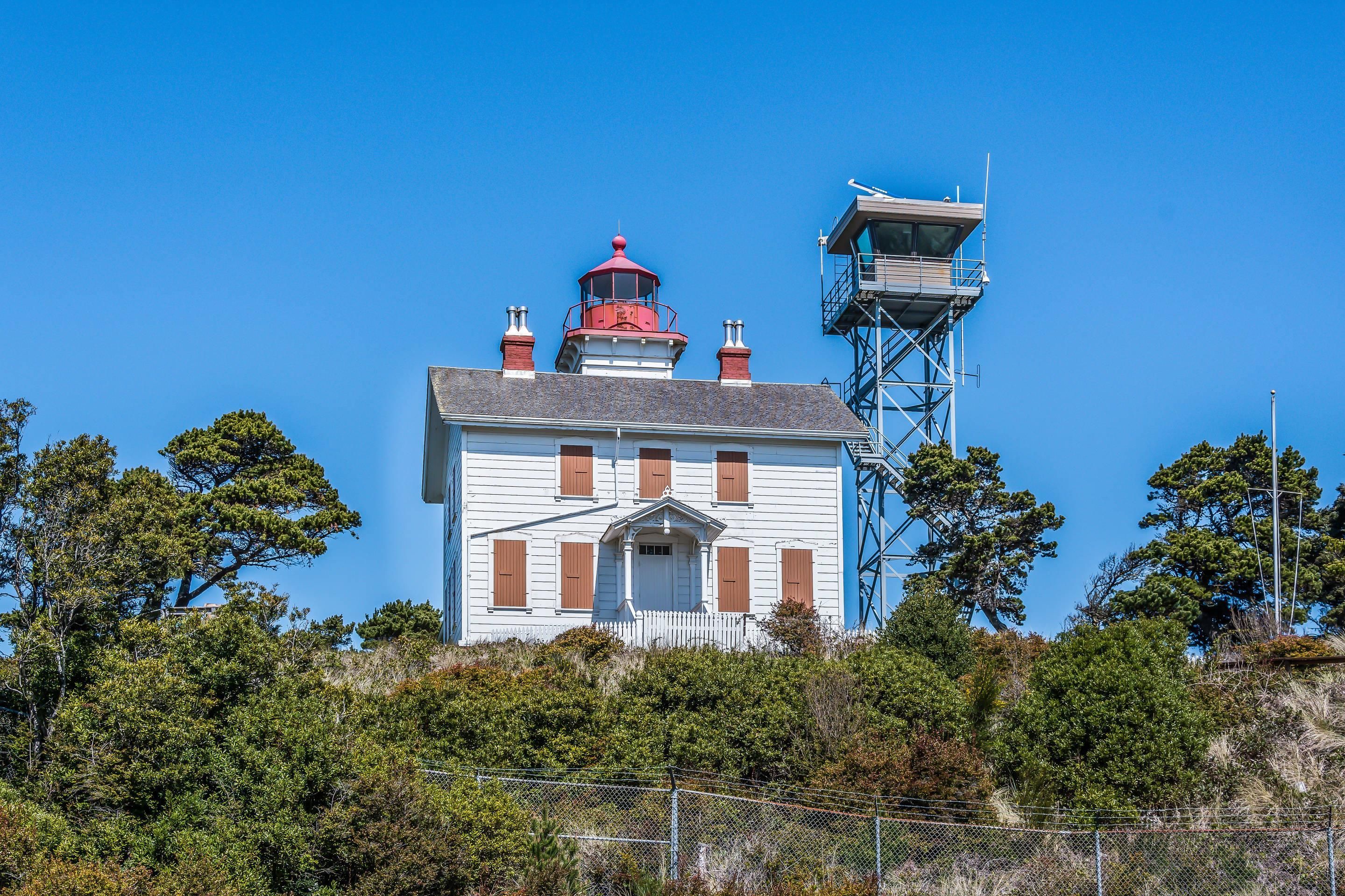 A lighthouse with a red roof, white walls, and a metal tower.