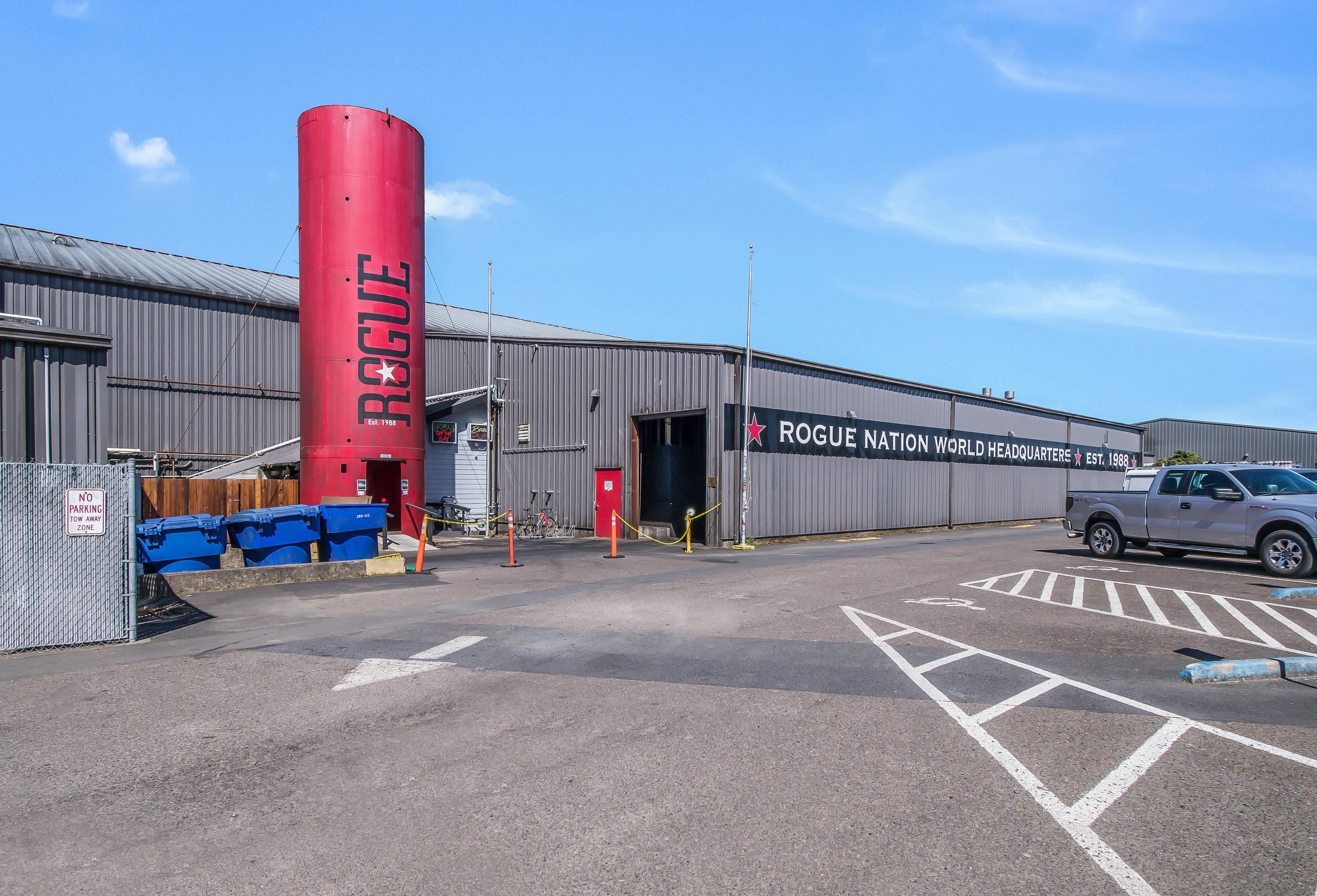 A building with a prominent red cylindrical structure labeled 'ROGUE' and a sign indicating 'ROGUE NATION WORLD HEADQUARTERS EST. 1988'.