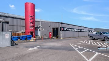 A building with a prominent red cylindrical structure labeled 'ROGUE' and a sign indicating 'ROGUE NATION WORLD HEADQUARTERS EST. 1988'.