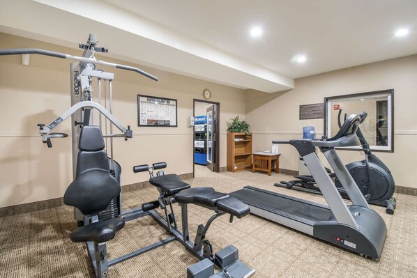 A gym with exercise equipment, a treadmill, and a wall-mounted clock.