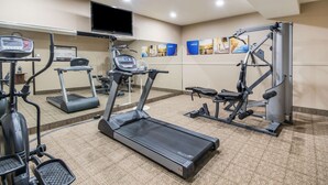 A gym with treadmills, elliptical machines, and weightlifting equipment.