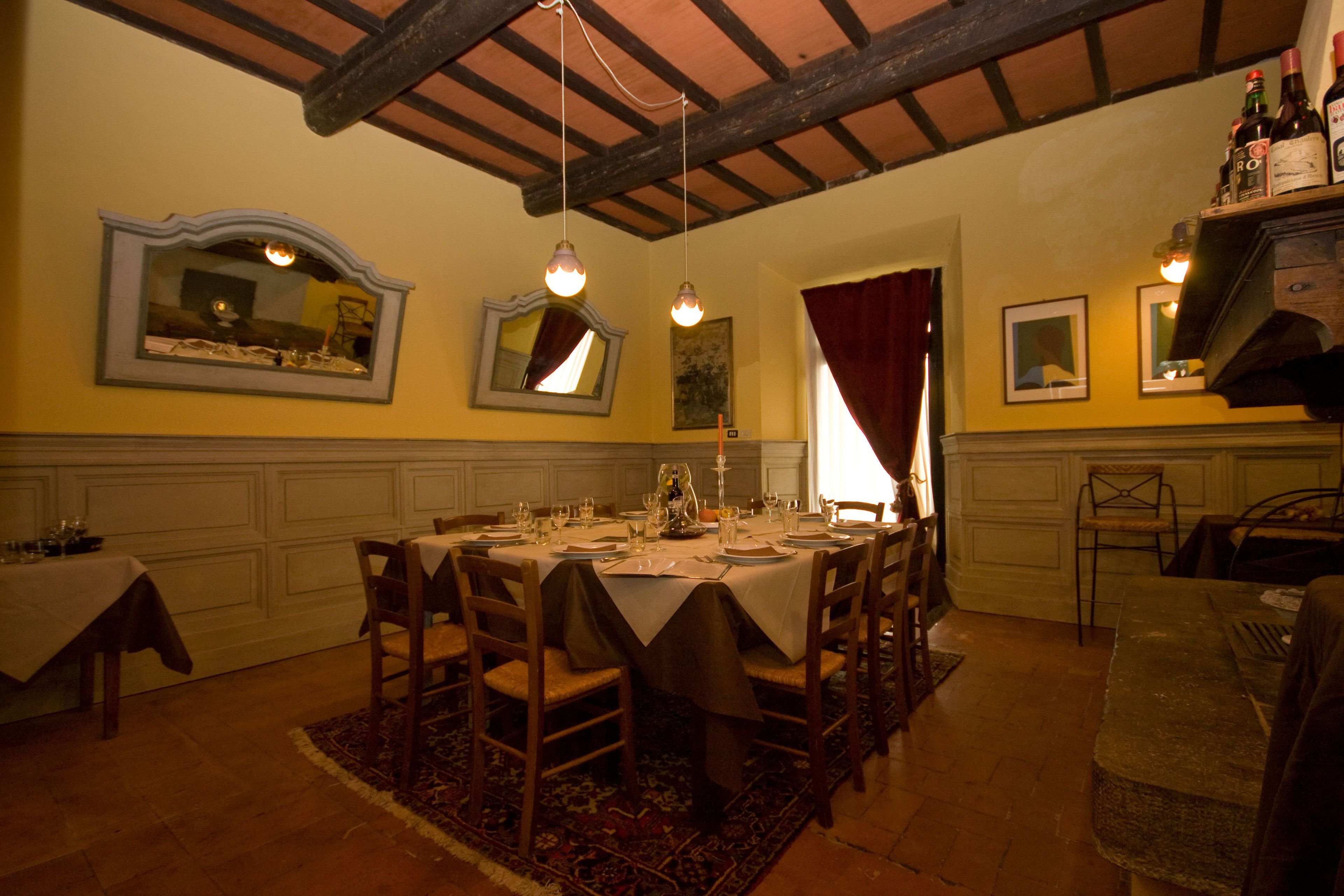 Une salle à manger avec une grande table dressée pour six personnes, entourée de chaises en bois.