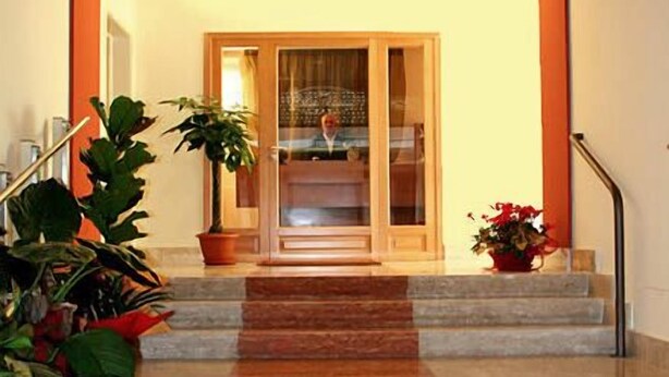 Een trap die leidt naar een kamer met een glazen deur, omringd door potplanten.