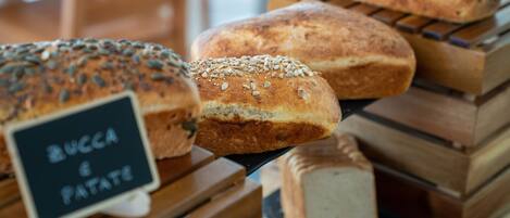 A display of various breads and pastries, including a sign that reads "BUCCA & PATATE".