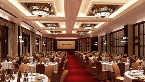 Un salón de banquetes con mesas redondas, sillas y candelabros.