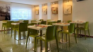 A dining area with tables and chairs, a window with a view, and framed artwork on the walls. - Lucca In Villa Elisa & Gentucca (Lucca)