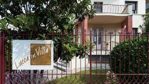 A sign for 'Bed & Breakfast Lucca' with a view of a building and a red metal fence. - Lucca In Villa Elisa & Gentucca (Lucca)