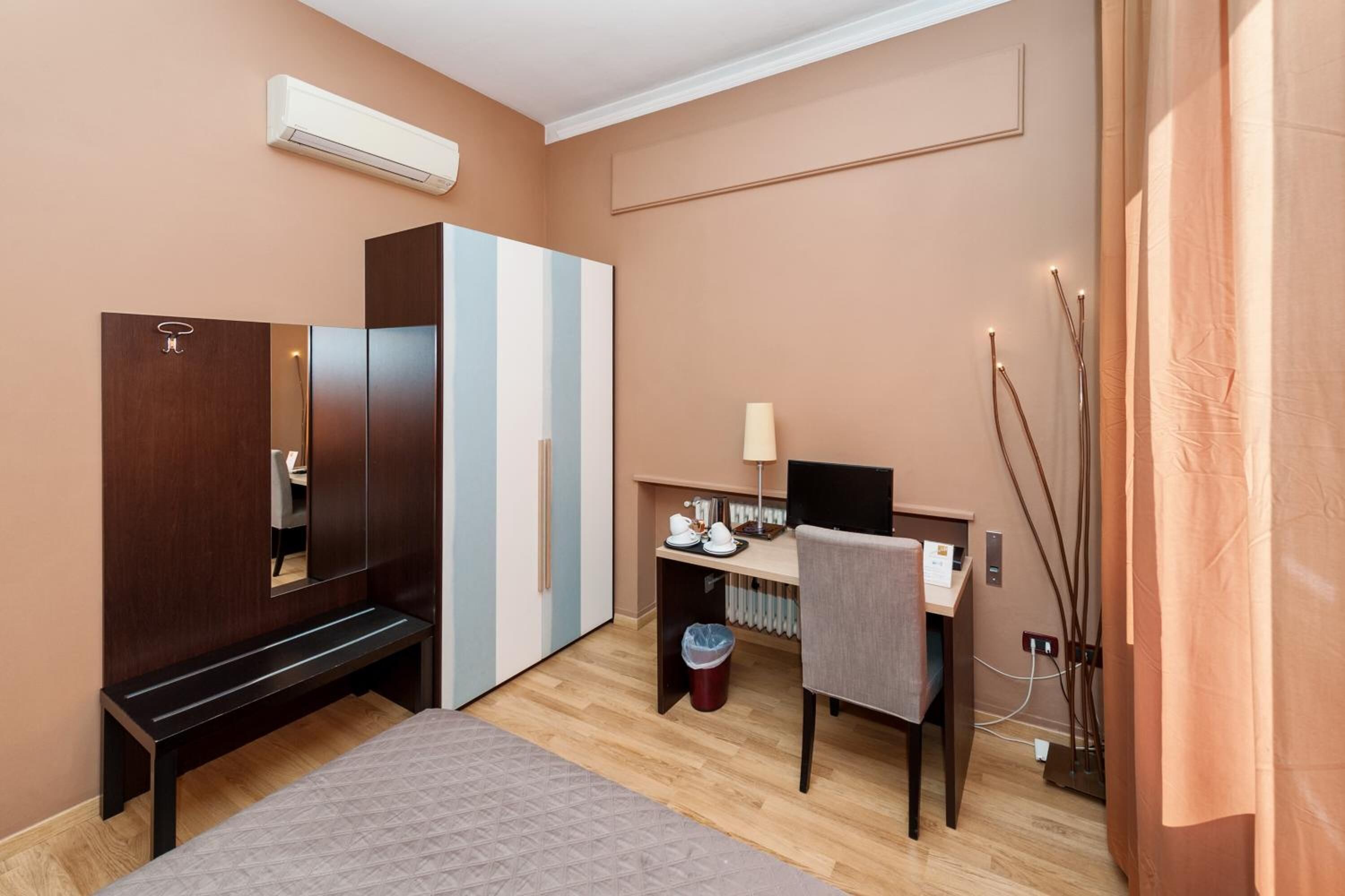 Quarto com cama, guarda-roupa, escrivaninha e cadeira.