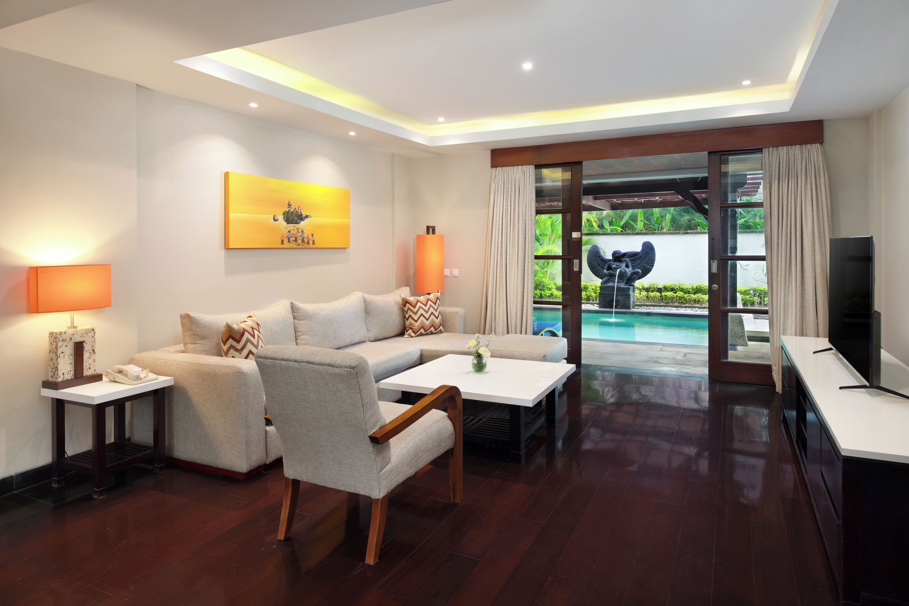Una sala de estar moderna con un sofá, un sillón, una mesa de centro y un televisor.