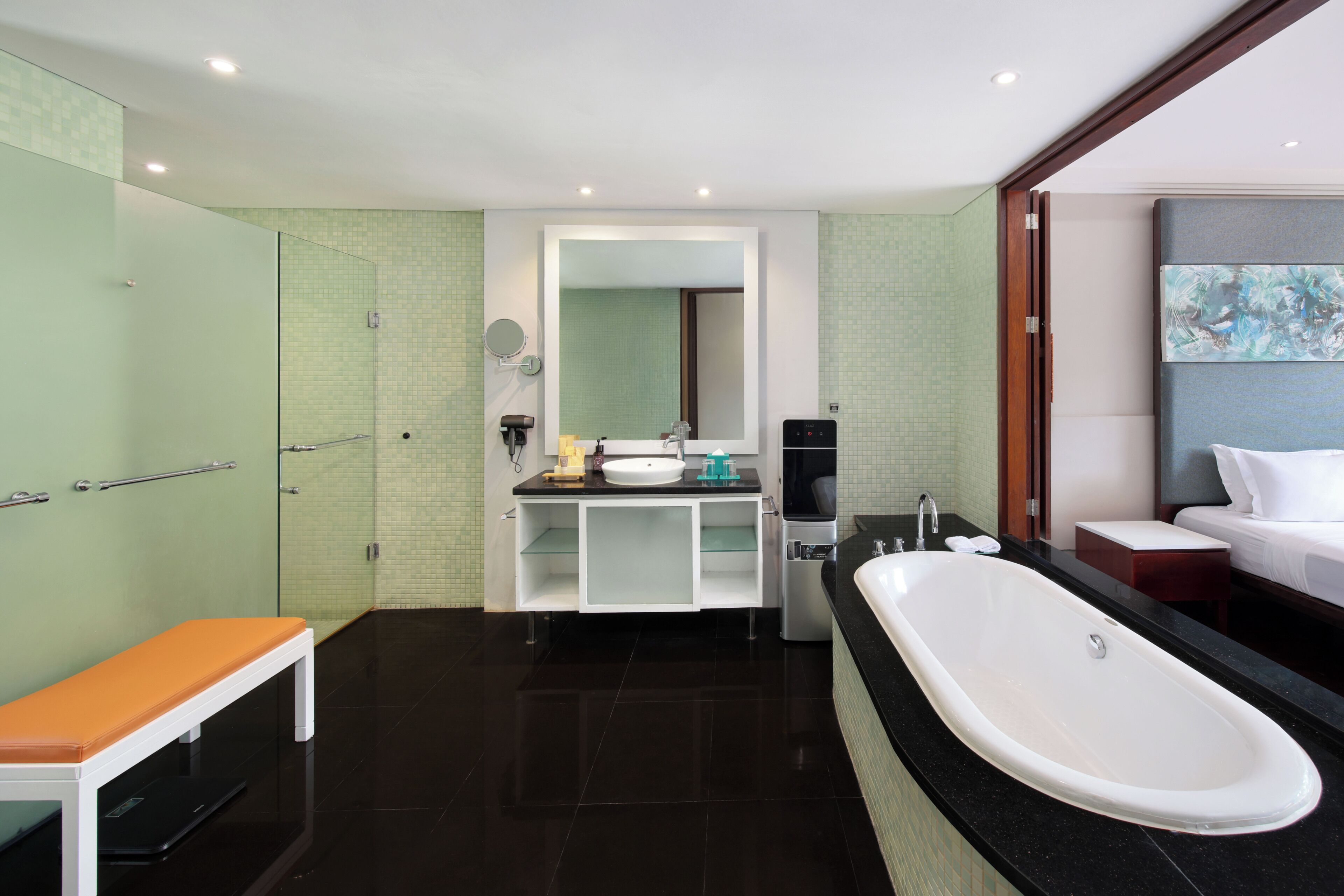 A modern bathroom with a bathtub, a vanity with a mirror, and a bench.
