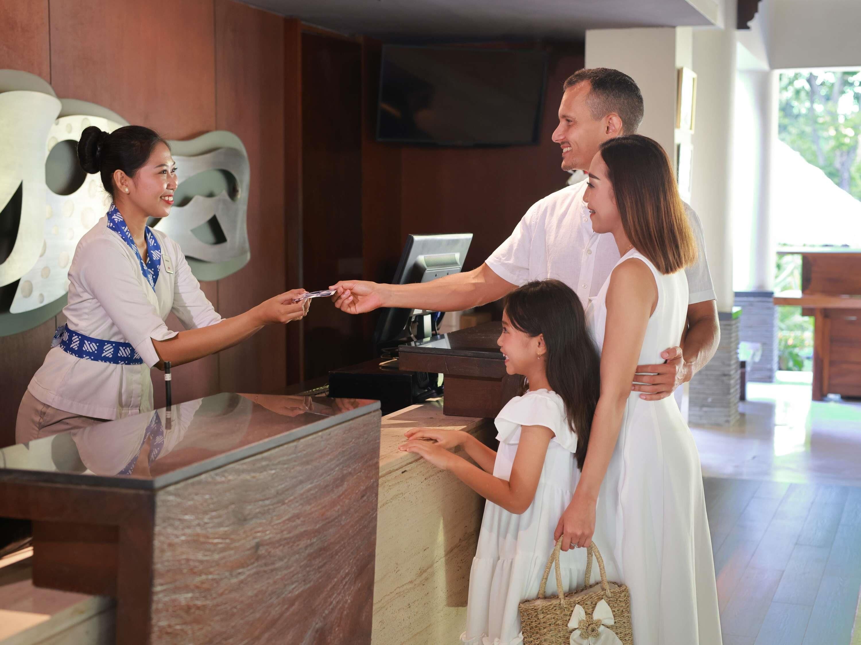 A reception desk with a modern design, a digital screen, and a wooden counter.