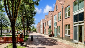 A row of brick buildings with large windows and a paved walkway. - Ribe Byferie Resort (Ribe)