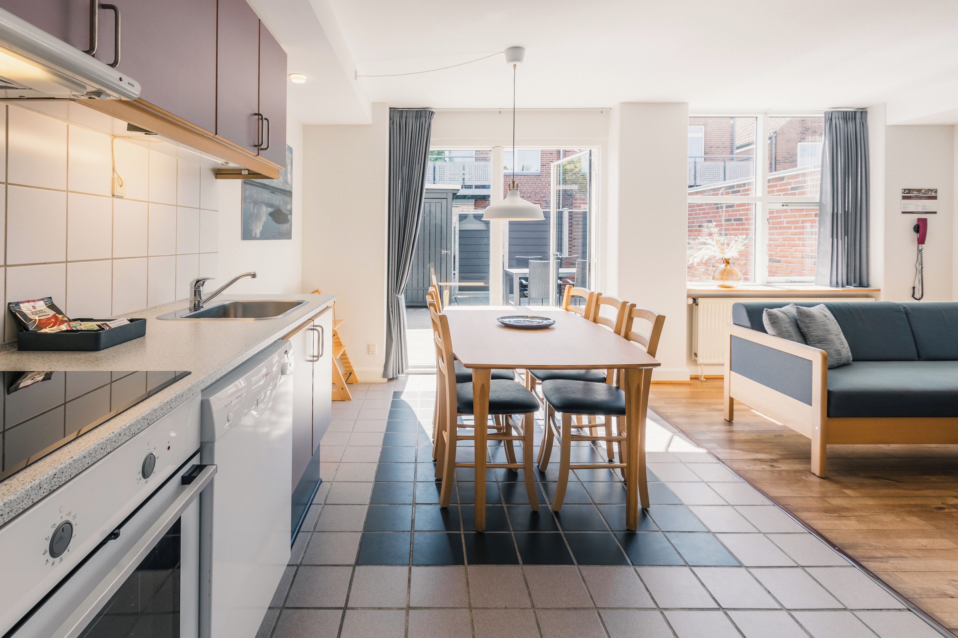 Una cocina moderna con comedor, sofá y vistas al exterior.