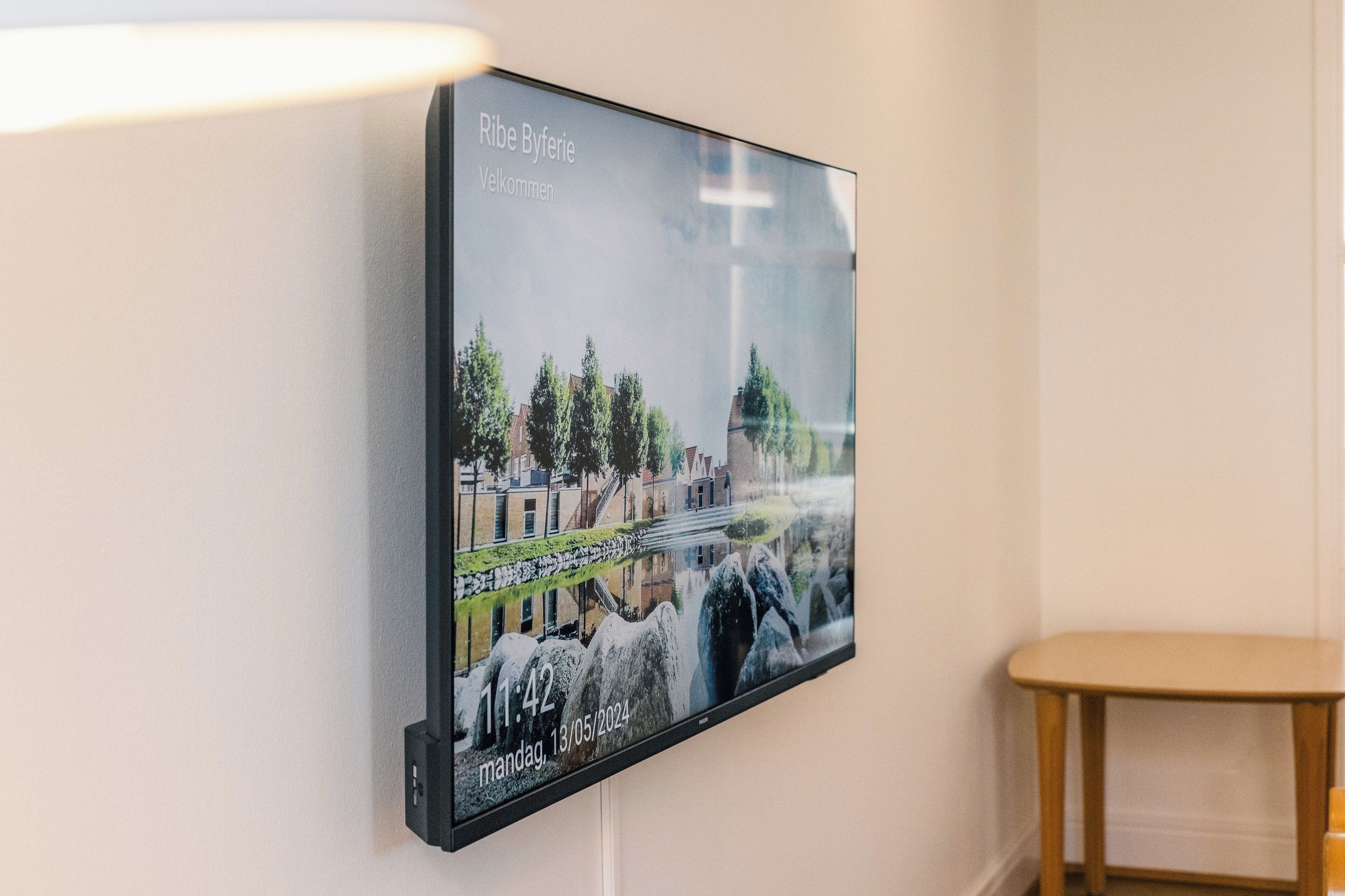 A wall-mounted digital display with a scenic image and text.