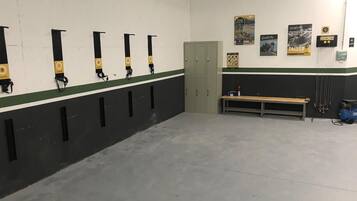 A locker room with multiple lockers, a bench, and wall decorations.