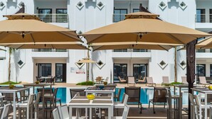 Un espace aménagé au bord de la piscine, avec des sièges et des parasols.