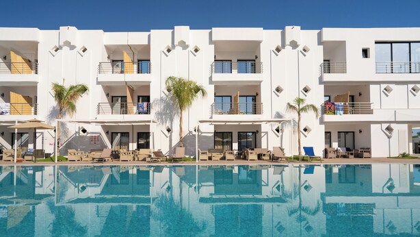 Un hôtel moderne doté d'une piscine, de nombreux balcons et d'espaces extérieurs aménagés pour se détendre.