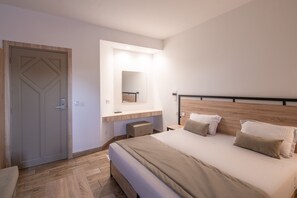 Un dormitorio con cama, mesitas de noche, un espejo y una puerta.