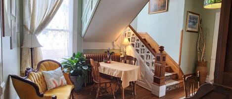 A cozy dining area with a wooden table, chairs, and a potted plant.