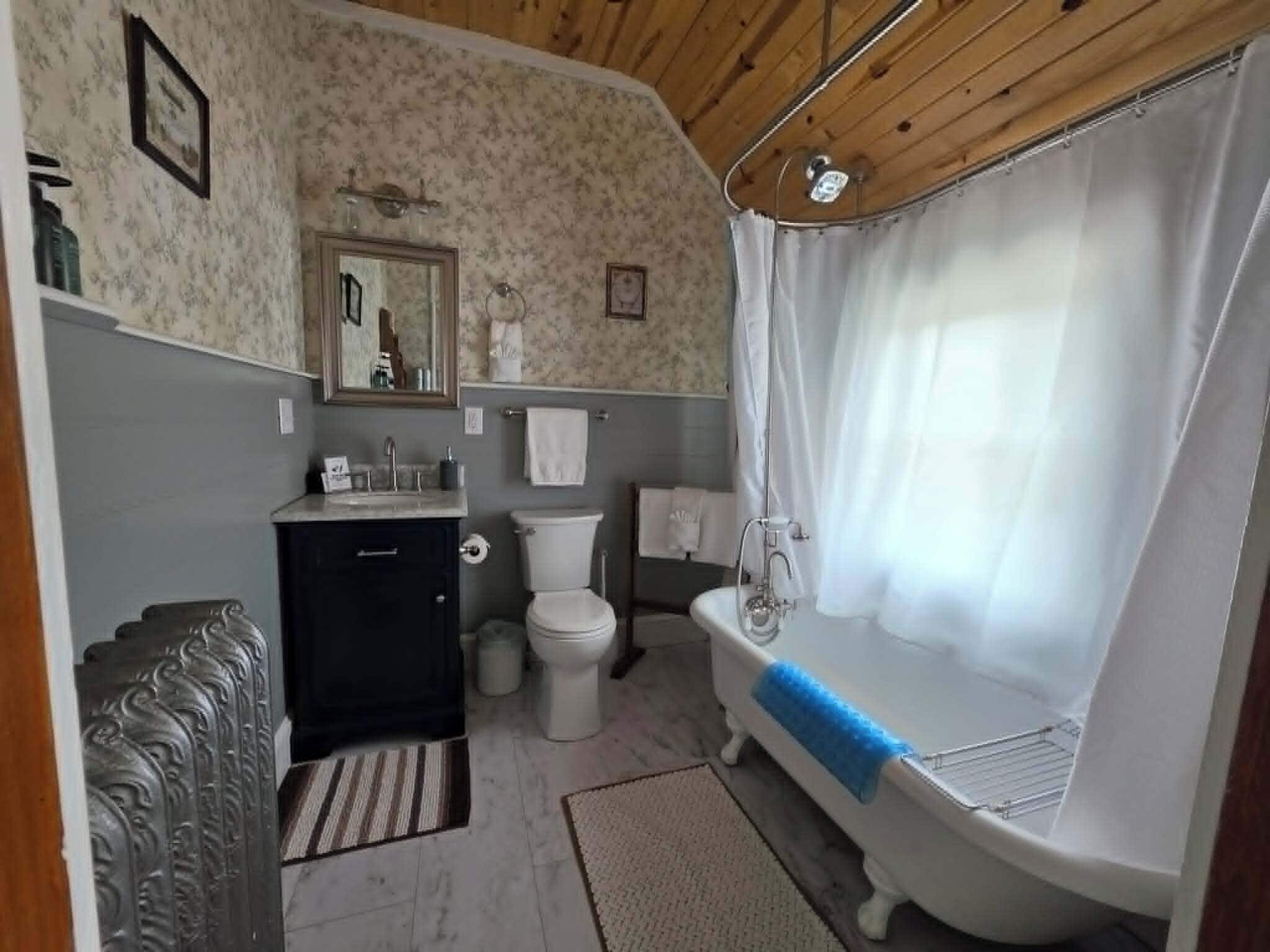 Et badeværelse med toilet, vask og badekar.