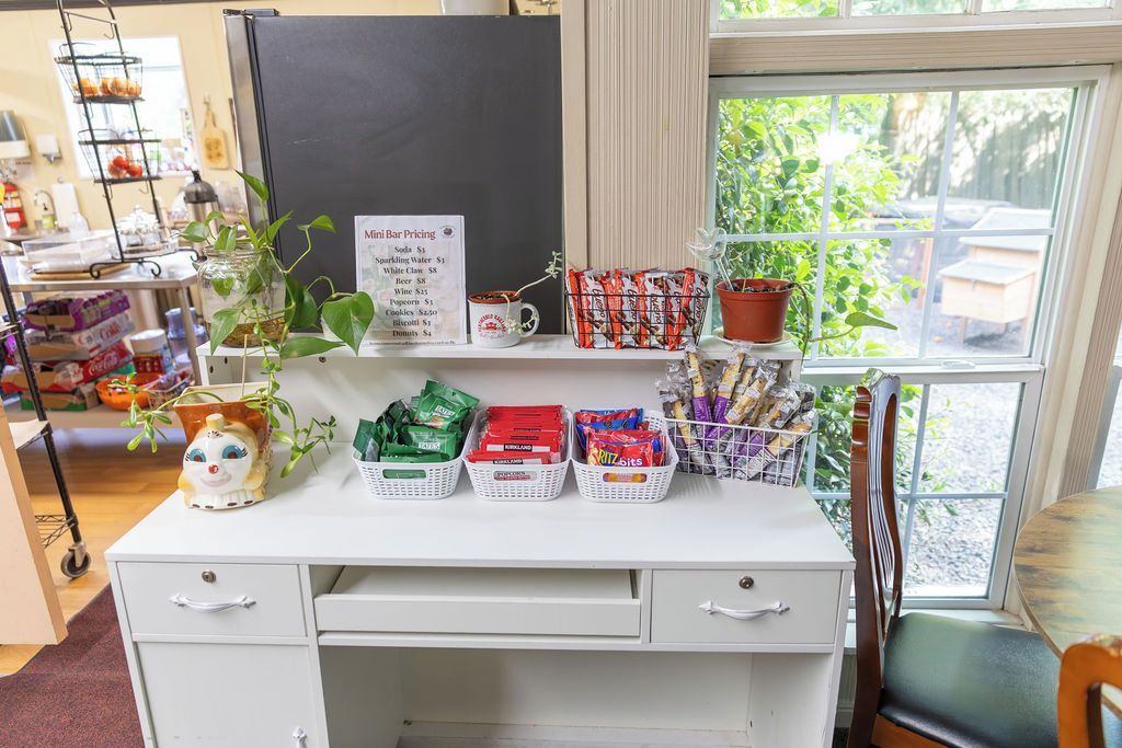 Un mini-bar avec une affiche indiquant les prix, divers en-cas et un chat décoratif en céramique.