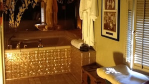 A spa room with a bathtub, a bench, and a framed picture on the wall. - Featherbed Railroad B&B Resort (Nice)