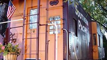Un viejo vagón de pasajeros de Southern Pacific, con una bandera, ventanas y una puerta.
