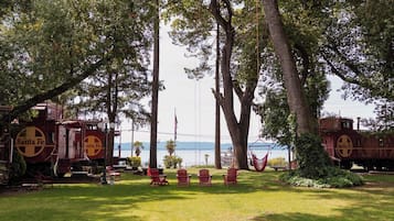 Nurmikenttä, jossa on puita, ja taustalla näkyy punainen junanvaunu, jonka kylkeen on maalattu teksti ”Santa Fe”.