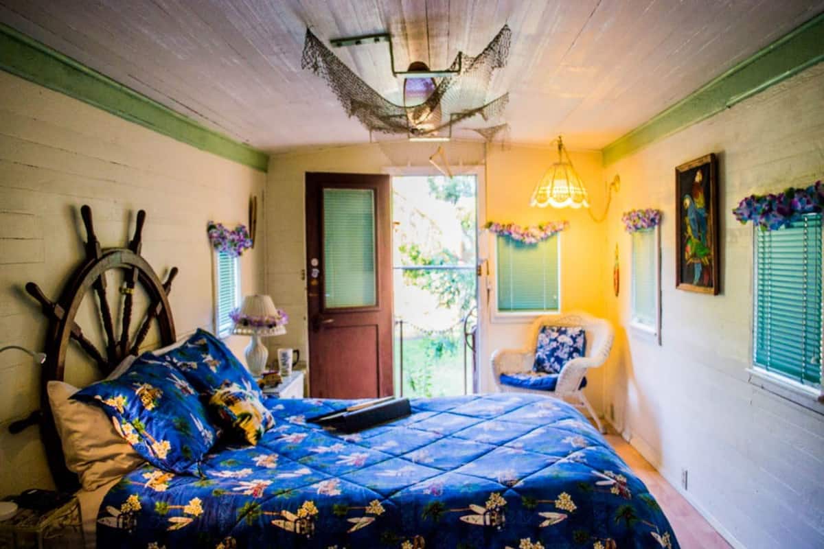Une chambre à coucher avec un lit, une chaise, une porte et une fenêtre.