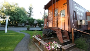A Southern Pacific train car converted into a stationary building with a porch and steps. - Featherbed Railroad B&B Resort (Nice)