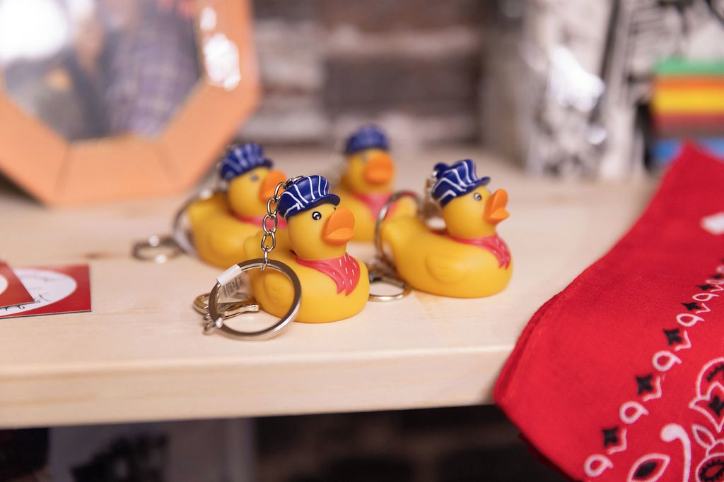 Rubber ducks with keychains on a wooden surface.