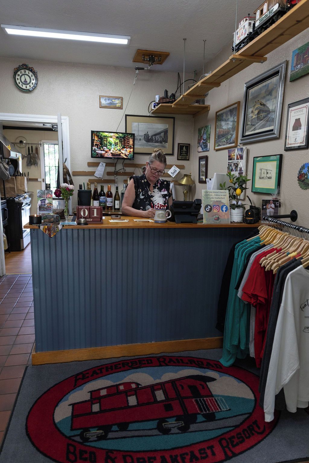 A restaurant counter with a vintage train-themed decor, including a clock and framed pictures on the wall.