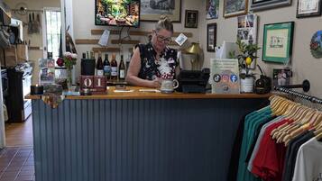 A restaurant counter with a vintage train-themed decor, including a clock and framed pictures on the wall.