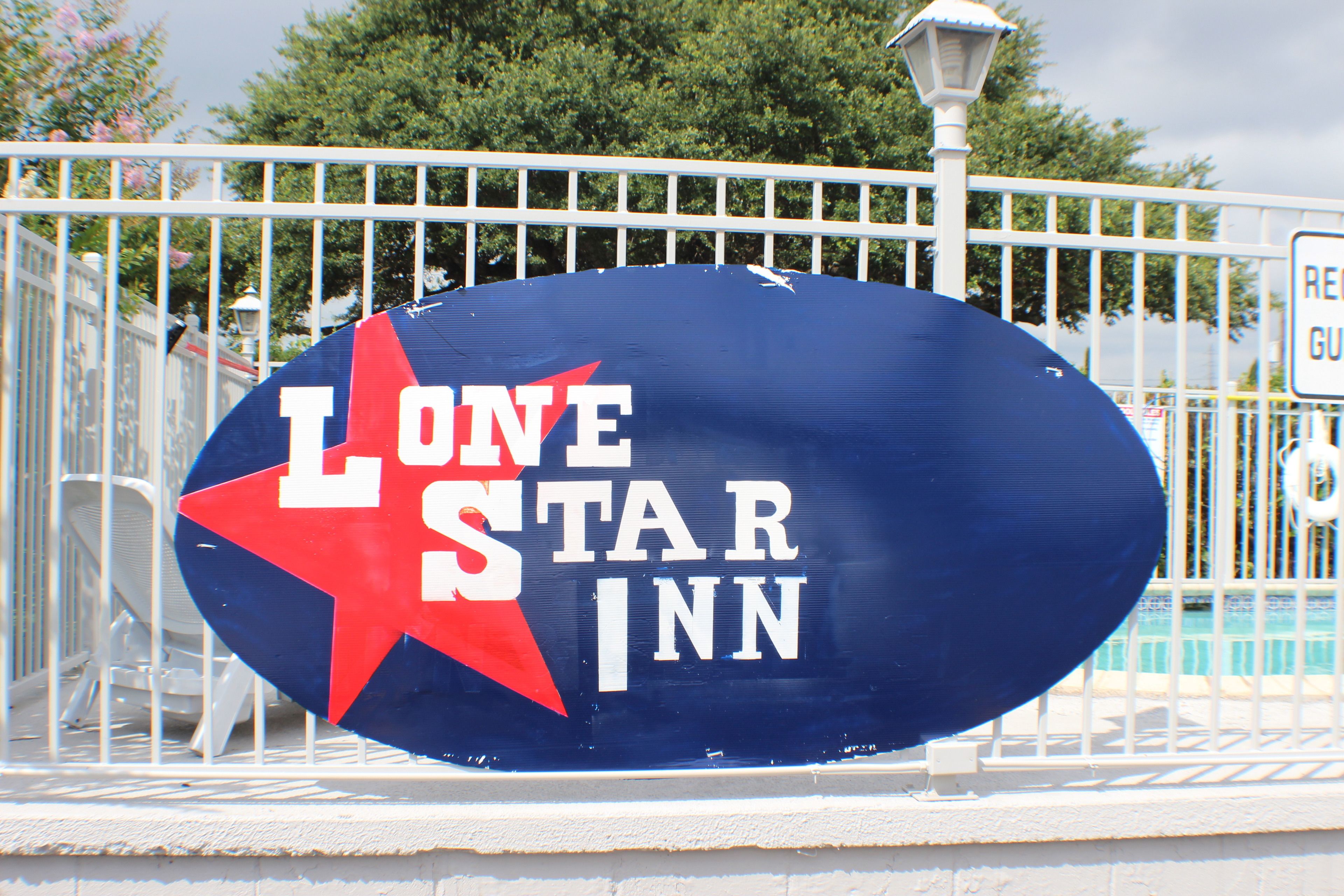 A sign for Lone Star Inn with a red star and white lettering.