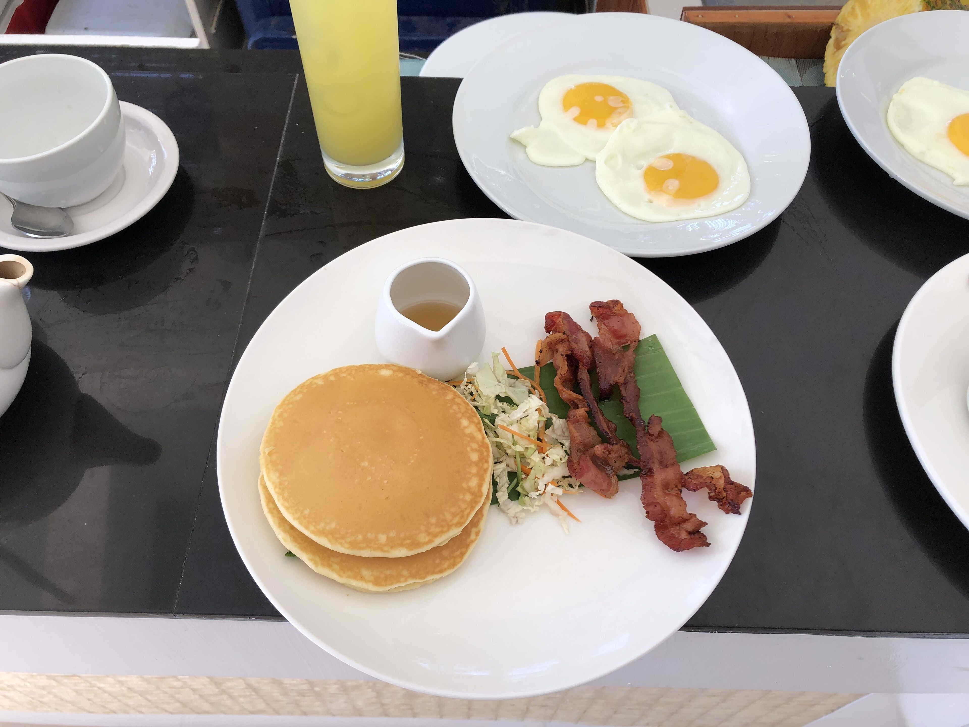 A breakfast plate with pancakes, bacon, and eggs.