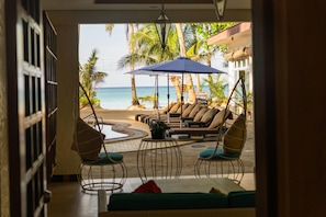 Un salon de plage avec vue sur l’océan, des places assises en plein air et un panneau indiquant un plat philippin spécial.