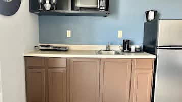 A compact kitchen with a microwave, coffee maker, and refrigerator.