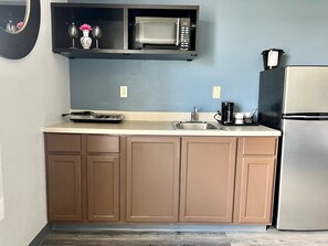 A compact kitchen with a microwave, coffee maker, and refrigerator. - HomeTowne Studios & Suites By Red Roof Washington (Washington)