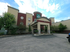 A hotel with a covered entrance, a parking lot, and a clear sky. - HomeTowne Studios & Suites By Red Roof Washington (Washington)