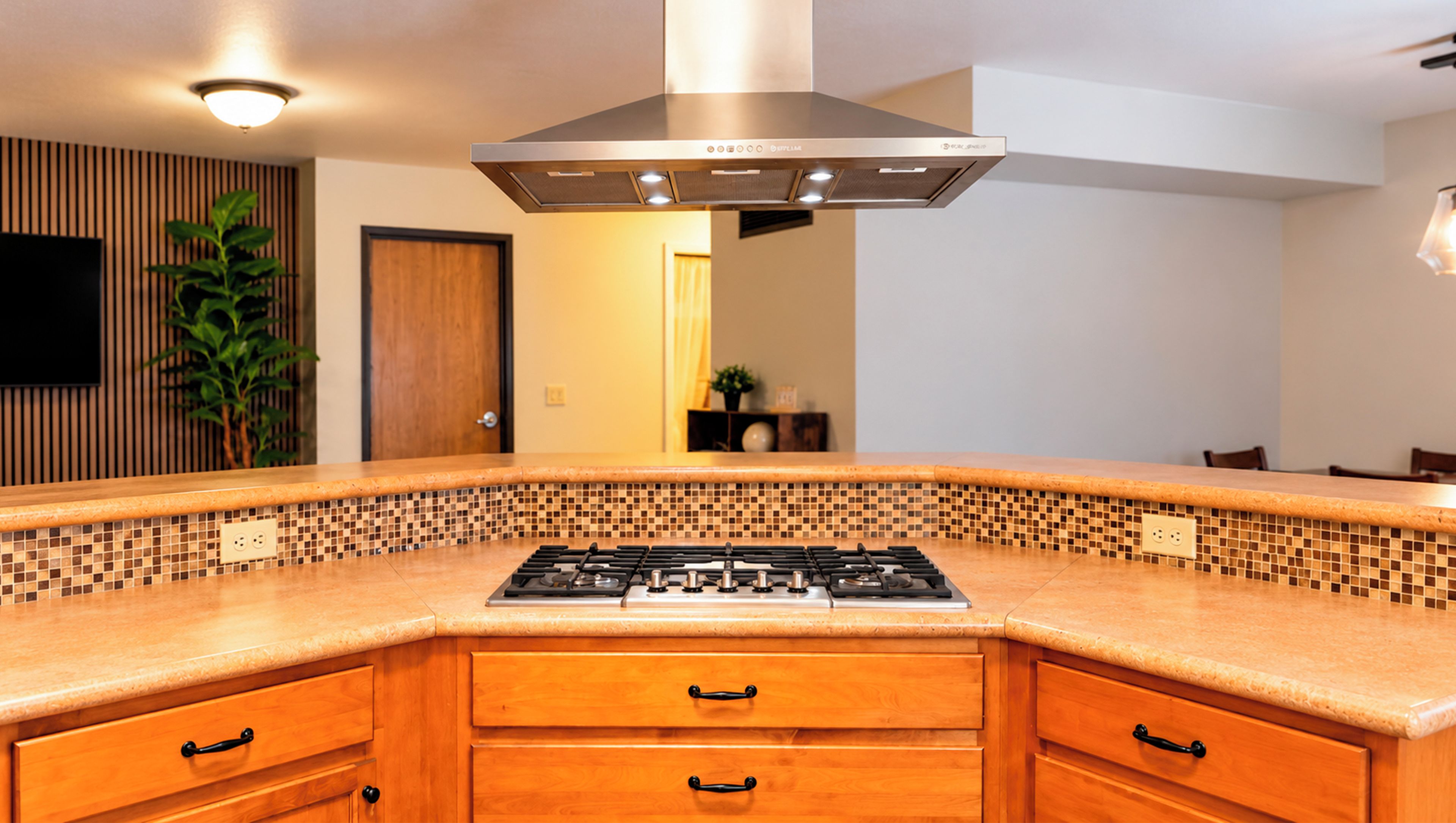 A kitchen with a central island, a stove, and a modern range hood.