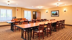 A conference room with a long table and chairs, a fire alarm, and a framed picture on the wall. - Manitou Pikes Peak Hotel (Manitou Springs)