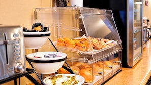 A breakfast buffet with various pastries, muffins, and bagels. - Manitou Pikes Peak Hotel (Manitou Springs)
