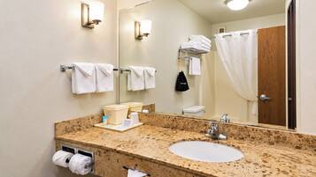 A bathroom with a sink, mirror, towel rack, and a shower curtain.