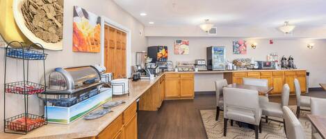 A hotel kitchen with a buffet, seating area, and various amenities.