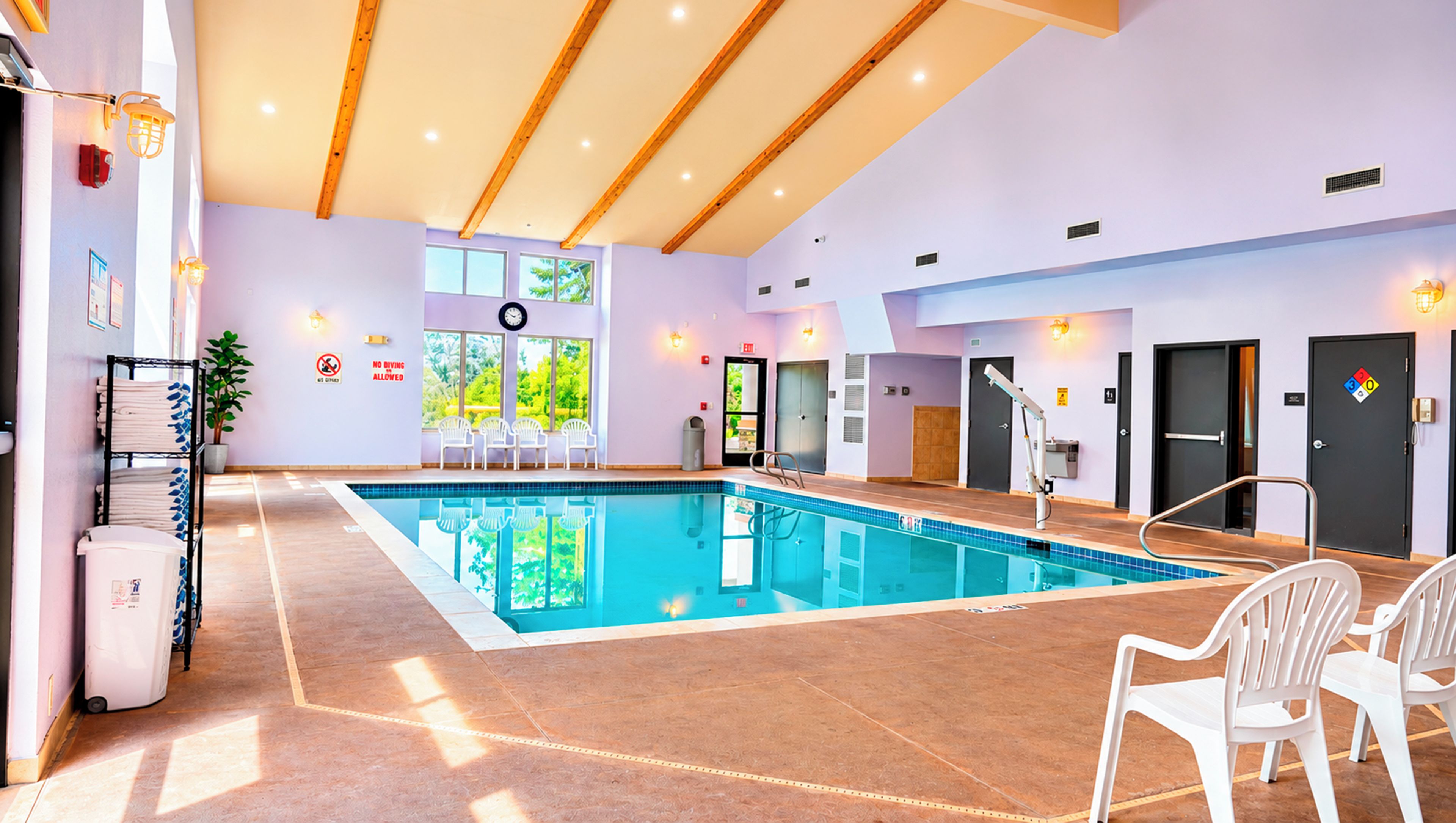 A swimming pool with chairs and a changing room area.